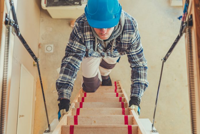 word-image Construction Worker Walking Upstairs To Take a Look at House Attic. Wooden Second Level Stairs.