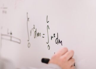 Improve your Mathematics knowledge with a tutor person writing on white paper