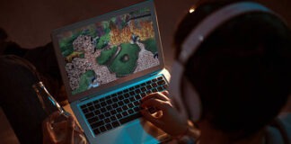 Man playing videogame on laptop Relaxation. Top view of a gamer playing videogame on the laptop while sitting on the sofa and having a drink in the evening gaming laptop stock pictures, royalty-free photos & images