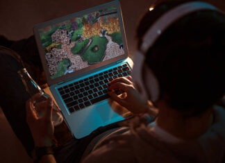 Best 14 inch display gaming laptop Man playing videogame on laptop Relaxation. Top view of a gamer playing videogame on the laptop while sitting on the sofa and having a drink in the evening gaming laptop stock pictures, royalty-free photos & images