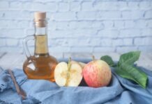 How Apple Cider Vinegar Can Improve Your Health clear glass bottle with red liquid beside sliced lemon on blue textile