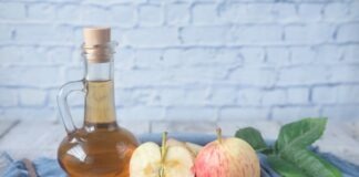 clear glass bottle with red liquid beside sliced lemon on blue textile