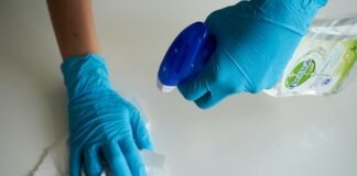 person in blue gloves holding white textile