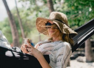 Top 10 women’s straw hat for perfect styling in summers woman lying on black hammock while holding phone