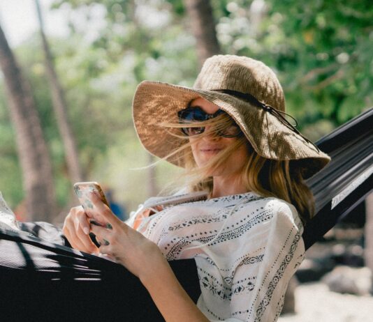 Top 10 women’s straw hat for perfect styling in summers woman lying on black hammock while holding phone