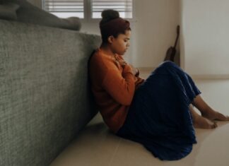 Ways To Help Your Child if They Have Anxiety at School man in orange long sleeve shirt sitting on gray couch