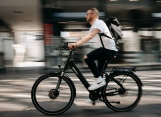 man in white dress shirt and black pants riding on bicycle