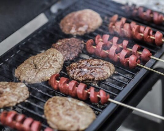 Steaks and Skewered Sausages on Grill
