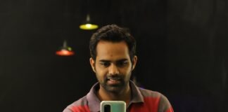 man in red and gray striped crew neck t-shirt holding gold iphone 6