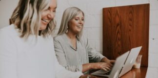 two women using laptops