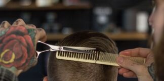 person holding white and gold hair comb