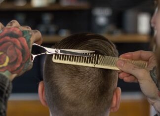 person holding white and gold hair comb