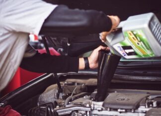 Understanding How Auto Insurance Subrogation Works man refilling motor oil on car engine bay