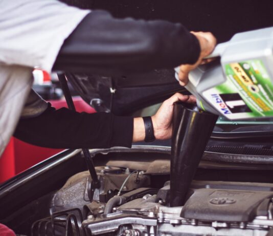Understanding How Auto Insurance Subrogation Works man refilling motor oil on car engine bay