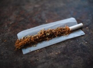 The Best Alternative to Smoking! NIIN Zero Tobacco Nicotine Pouches white cigarette stick on brown wooden table