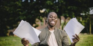Student with documents and laptop happy about getting into university