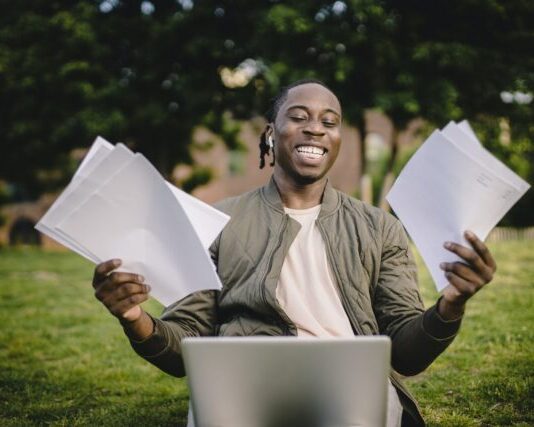 Student with documents and laptop happy about getting into university