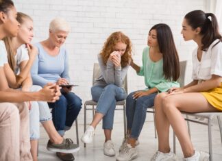 A group of people sitting in chairs Description automatically generated with medium confidence