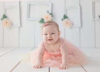 girl crawling on white floor while smiling