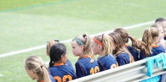 girls sitting on bench during daytime