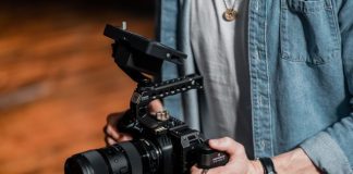 person in blue denim jacket holding black dslr camera