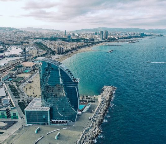 clear glass building near sea under grey sky