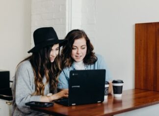 Can Two People Live Comfortably in a Studio Apartment? two woman sitting near table using Samsung laptop