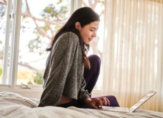 8 Activities That You Can Do to Kill Your Time A woman on a bed working on signing a contract with Docusign