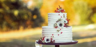 white and red floral cake on brown wooden stand