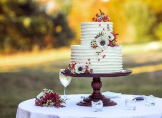 Most amazing and popular wedding cakes white and red floral cake on brown wooden stand