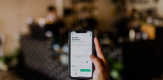 person holding black iPhone displaying stock exchange
