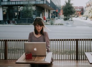 3 Ways to Balance Working Remotely and Have Fun While Traveling woman in gray shirt sitting on bench in front of MacBook