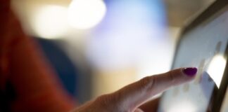 selective focus photography of person pointing at tablet computer
