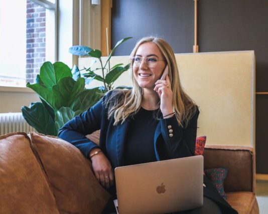 woman in blue long sleeve shirt using silver macbook