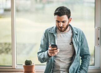 How Artificial Intelligence Will Transform Online Casino Games man holding a smartphone near the window