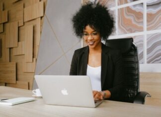 VPS Prestashop Woman in Black Blazer Sitting by the Table While Using Macbook
