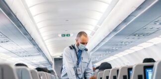 man in blue dress shirt standing in airplane
