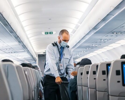 man in blue dress shirt standing in airplane