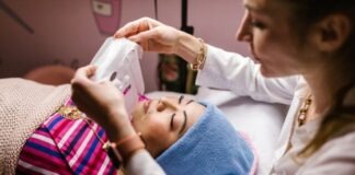 An Aesthetician Putting a Sheet Mask on Her Client's Face