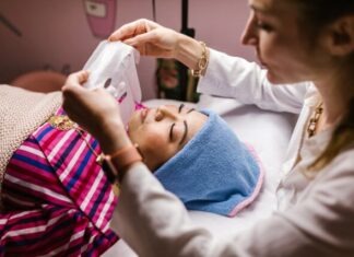 An Aesthetician Putting a Sheet Mask on Her Client's Face