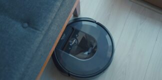 a robotic vacuum is on the floor next to a couch