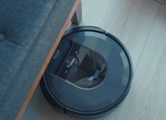 a robotic vacuum is on the floor next to a couch