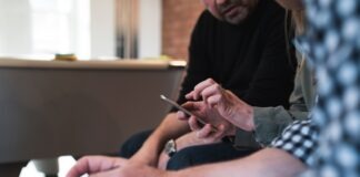 three peson sitting talking to each other