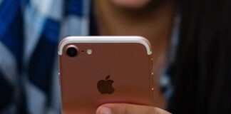 woman in blue and white plaid shirt holding gold iphone 6