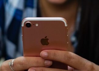 woman in blue and white plaid shirt holding gold iphone 6
