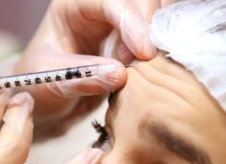 a woman getting her eyebrows examined by a doctor