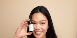 woman in white tank top holding white labeled bottle