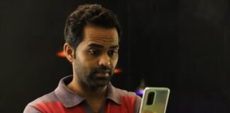 man in red and black striped polo shirt holding gold iphone 6
