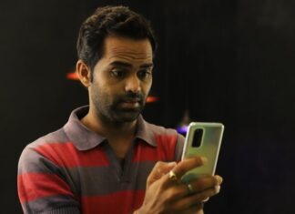 man in red and black striped polo shirt holding gold iphone 6