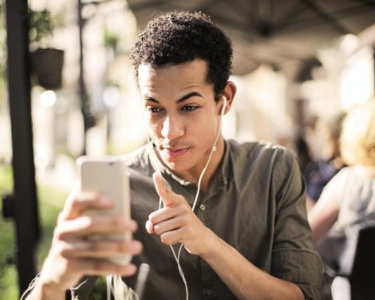 Selective Focus Photo of Man in Brown Button Up Shirt Holding Talking on the Phone
